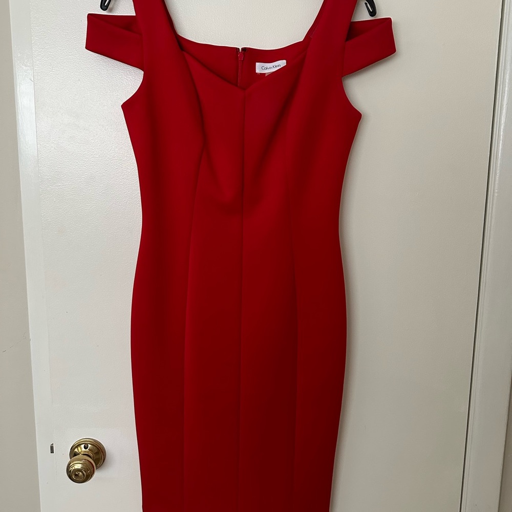 Bright red form fitting CALVIN KLEIN dress with shoulder cut outs